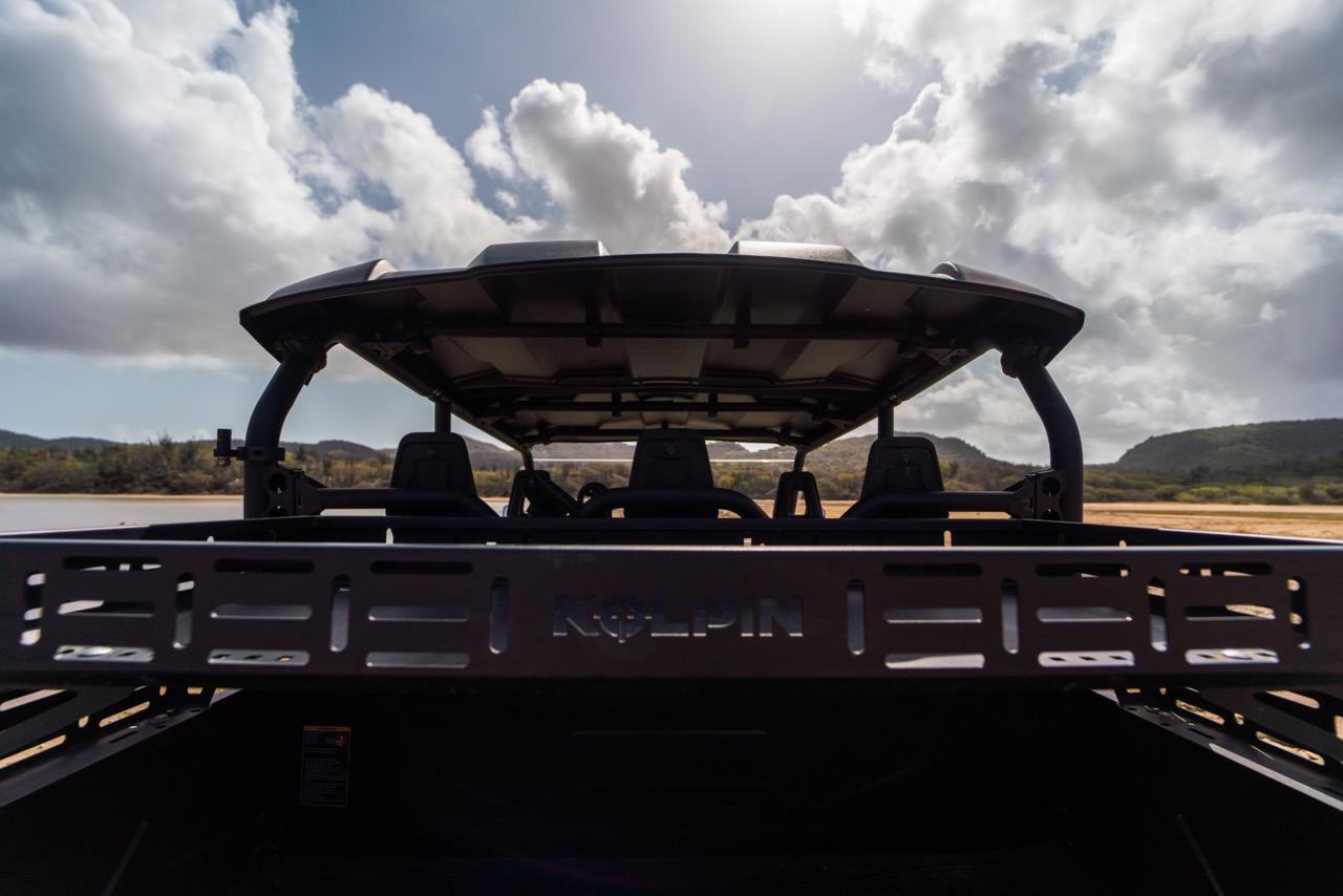 Family-friendly 4-seater Club Car golf cart awaiting adventure, with Bonaire's lush landscape in the background.